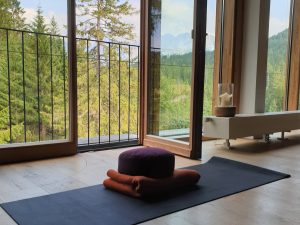 Eine Yogamatte liegt vor dem Fenster im Yogaraum mit Aussicht des Hotel Kranzbach bei Garmisch-Partenkirchen.